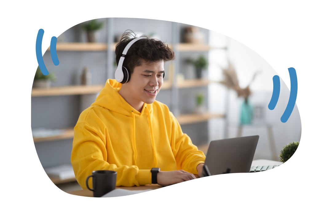 image of a young masculine teenager with headphones on working on a laptop